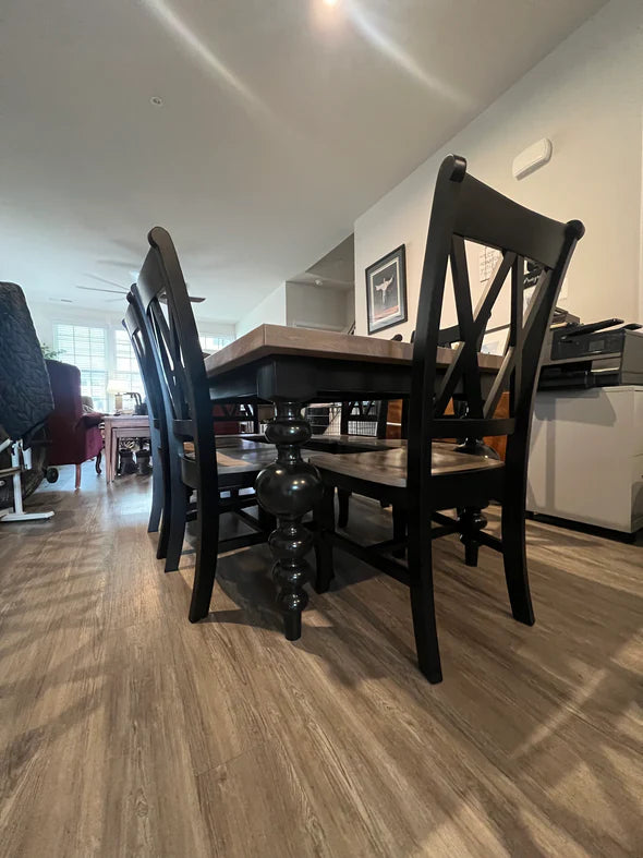 hardwood dining table light brown top with black legs and 8 matching chairs on light brown hardwood floor