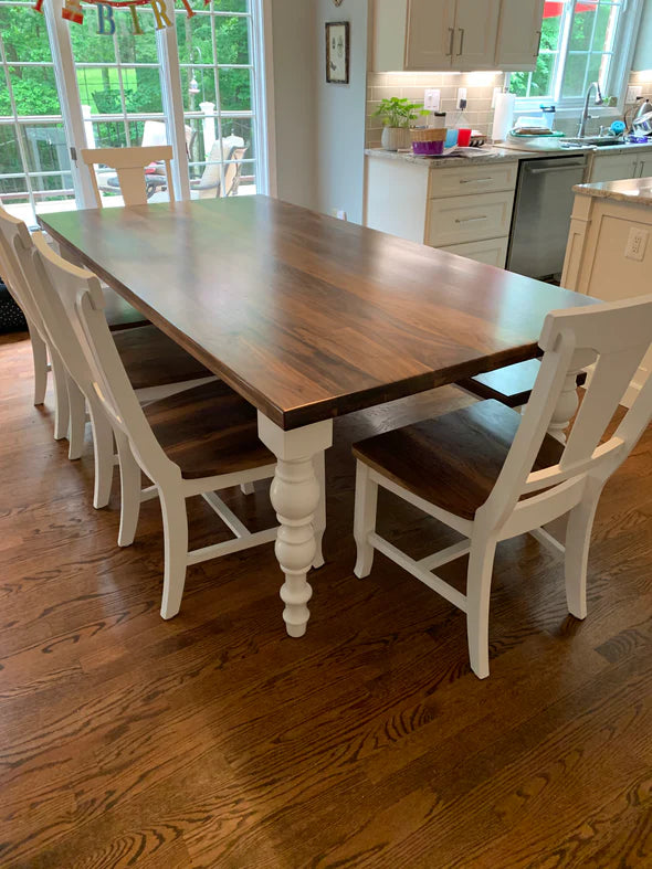 Hardwood dining table brown top with white legs 5 white chairs and a matching bench in kitchen