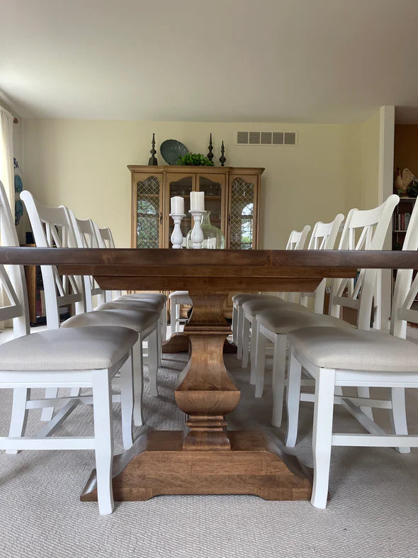 oak dining table with dark walnut stain white double X upholstered chairs in dining room
