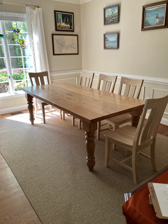 hardwood dining table natural wood color with 5 matching chairs on tan rug