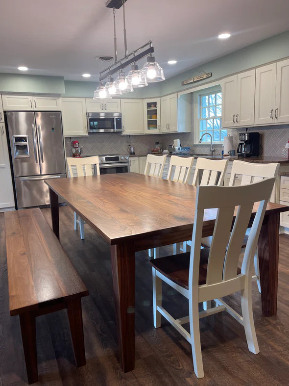 Hardwood dining table light brown stain bench and 6 white dining chairs in light kitchen